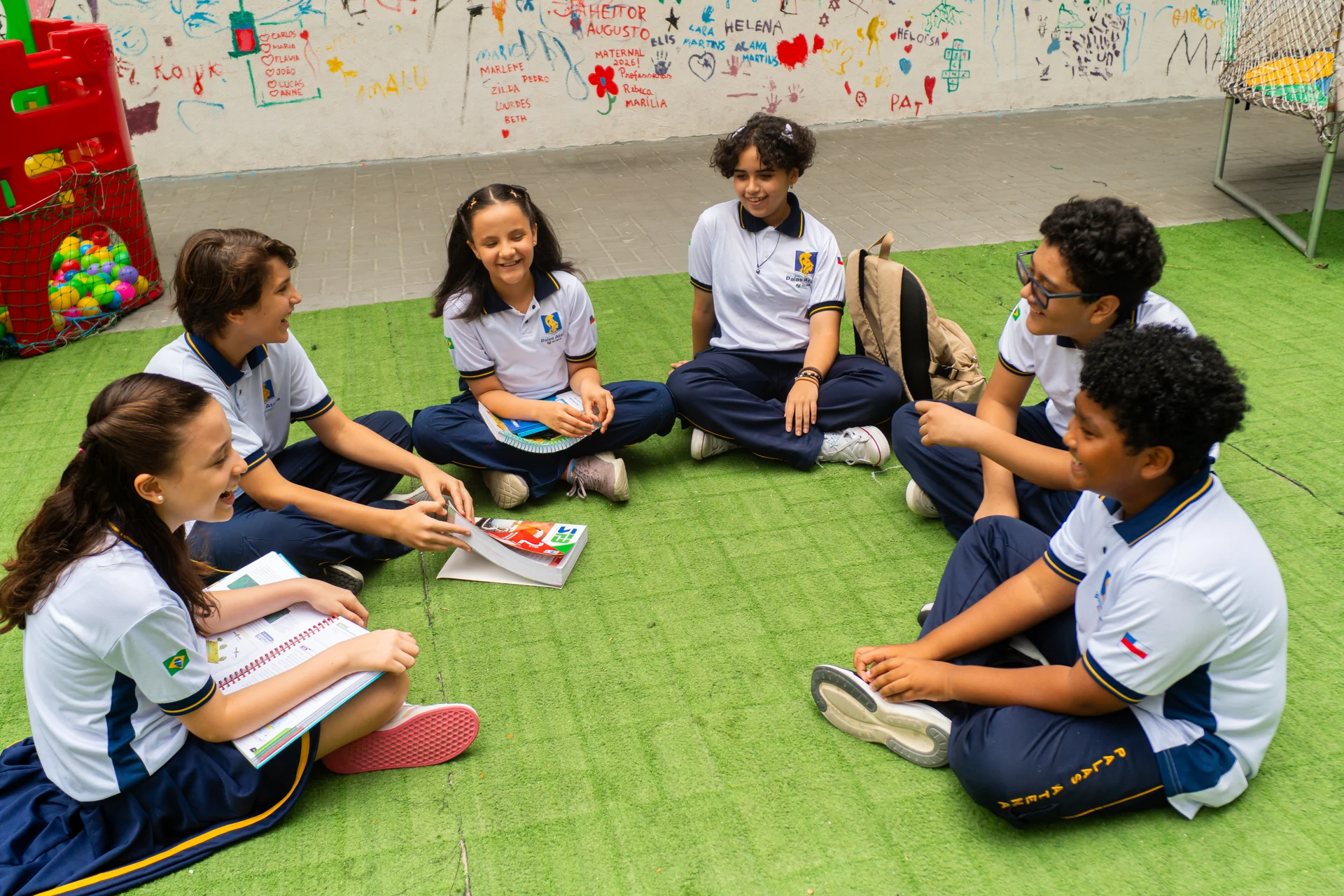 Alunos do Tempo Integral reunidos no pátio conversando e lendo juntos