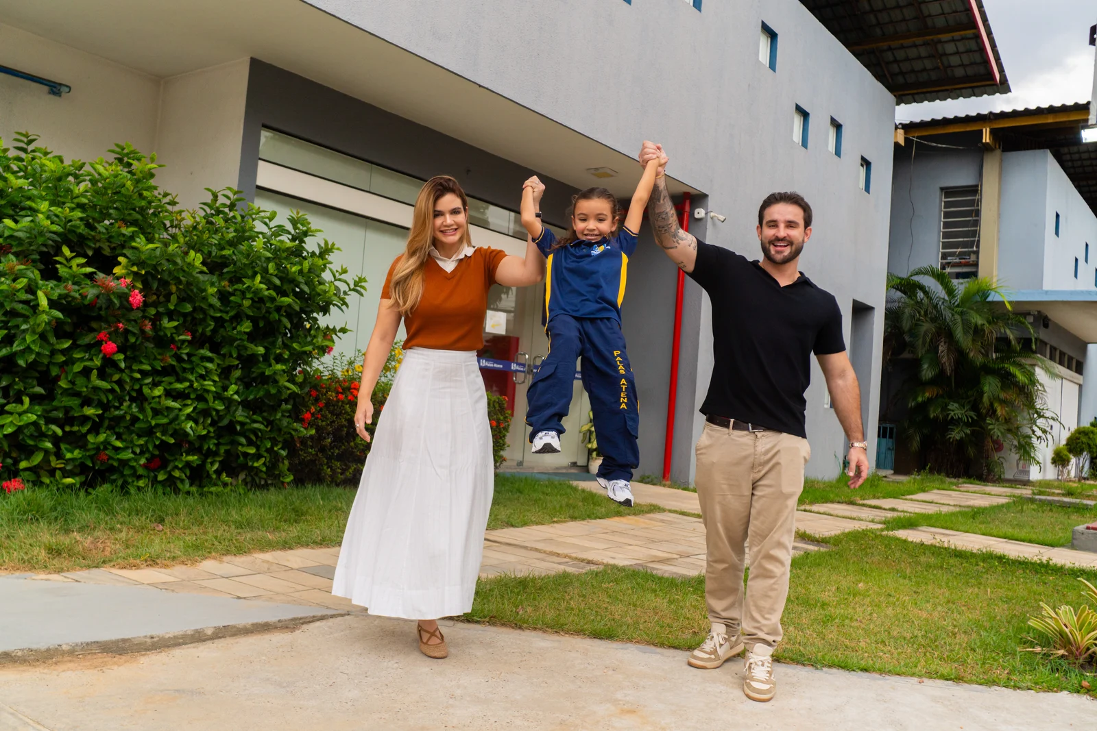 Família caminhando alegremente pelo pátio do Colégio Palas Atena